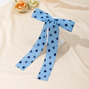 Barrette à cheveux ruban bleu clair avec motifs de cœurs bleus sur fond de tissu beige