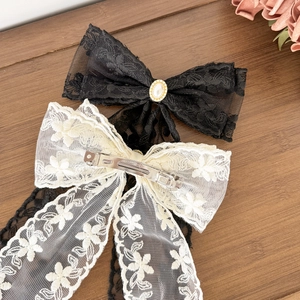 Elegant lace bow hair clips in black and cream white with central faux pearl decoration