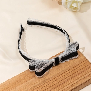 Detail van zoete kant hoofdband met zwarte strik en witte kanten bloemen afwerking