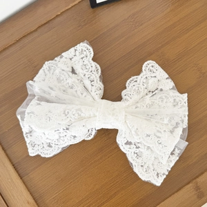 Barrette nœud en dentelle blanche élégante avec attache à ressort sur bois rustique