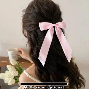 Pink satin bow hair clip with long ribbons shown on model back for sweet styling