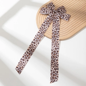 Fermaglio per capelli oversize con fiocco leopardato e lunghi nastri su vassoio in legno