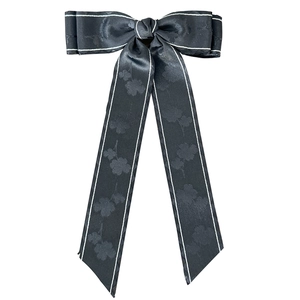 Eleganter schwarzer Haarclip mit floralem Jacquard-Muster, weißer Paspel und langen Bändern