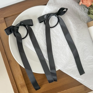 Dettaglio di eleganti elastici per capelli con fiocco in raso nero per acconciature