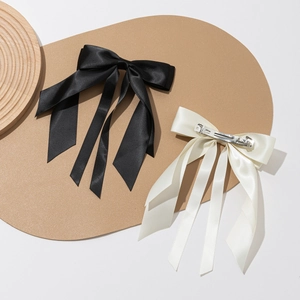 Elegant satin bow hair clips in black and cream white with smooth metal spring back clips