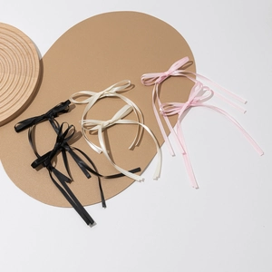 Elegant satin bow hair clips in black, beige, and pink with long flowing ribbons