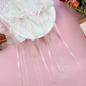 Dettaglio di fermagli in pizzo stile balletto con fiocchi di raso rosa e lunghi nastri