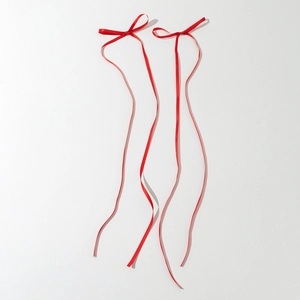 Vue détaillée d'une barrette à ruban rouge avec nœud élégant et longs rubans fluides
