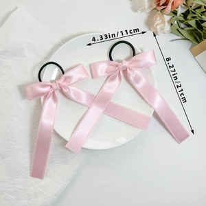 Close-up of pink satin bow hair ties with lace edges and dimensions 11cm by 21cm
