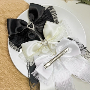 Three elegant lace bow hair clips with heart rhinestones in black, cream, and white