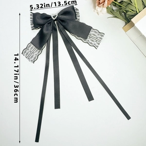 Detail of black lace bow hair clip with heart rhinestone and long silk ribbons