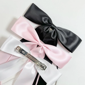 Elegant satin bow hair clips in black, pink, and white with silver metal spring clips