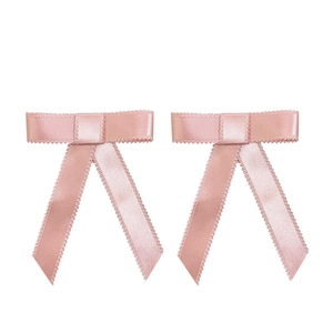 Paire de barrettes à nœuds en satin rose avec bordure picot sur fond blanc uni