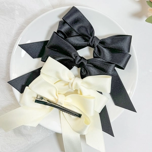 Elegant French satin bow hair clips in black and cream white with long flowing ribbons