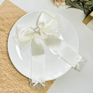 Elegant cream satin bow hair clip with lace trim and heart rhinestone center detail