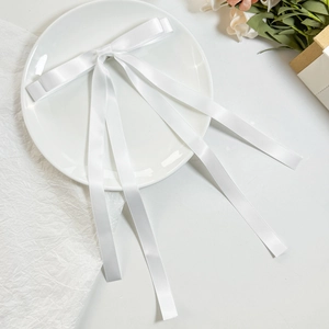 Elegante fermaglio per capelli in raso bianco con doppio fiocco e lunghi nastri su piatto