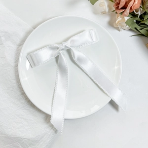 Eleganter weißer Satin-Haarschleife mit zarter Spitze auf einem minimalistischen Teller