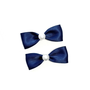 Dettaglio di fermagli per capelli a fiocco in raso blu navy con perla centrale