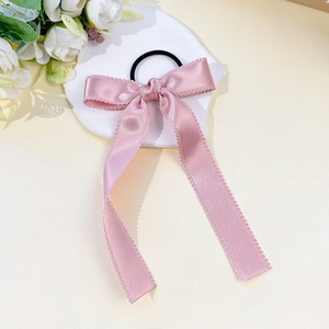 Close-up of pink satin bow hair tie with scalloped edges and high-elastic band