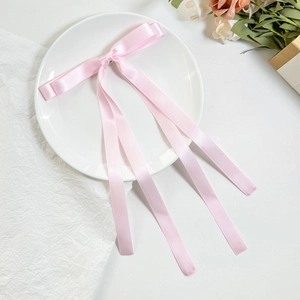 Fermaglio per capelli a doppio fiocco in raso rosa con nastri lunghi su piatto