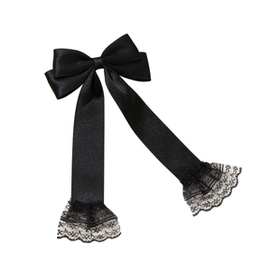 Elegant black satin bow hair clip with long ribbons and delicate lace trim on white background