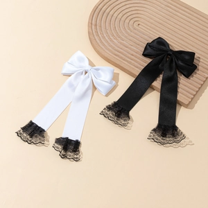 Lace-trimmed satin bow hair clips in black and white with long streamers and ribbons