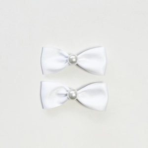 Dettaglio di fermagli per capelli a fiocco in raso bianco con decorazioni in perle crema
