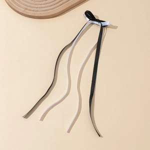 Detailed close-up of double-layered black and white satin ribbon bow hair clip