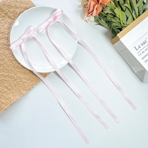 Set of two long pale pink satin ribbon bow hair clips with a romantic aesthetic design