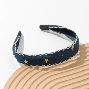 Detailed texture of blue denim headband with yellow star embroidery and wavy stitching