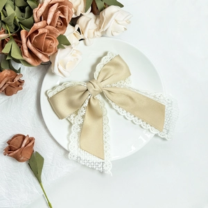 Elegant champagne gold satin bow hair clip with delicate lace trim for women