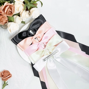 Elegant satin bow hair clips with long streamers in multiple colors on a decorative tray