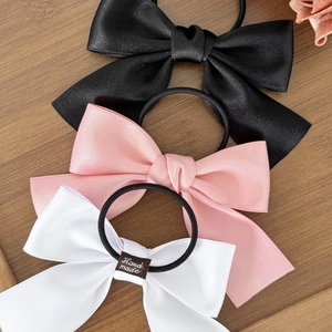 Three-piece satin bow hair ties set in black, pink, and white with handmade labels