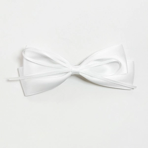 Detail shot of elegant white satin bow hairclip with multilayered silk ribbon texture