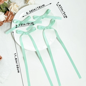 Detail view of mint green grosgrain ribbon bows showing 16cm width and 30cm long streamers