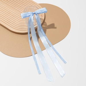 Détail d'un nœud papillon en ruban vichy bleu clair sur un verre texturé