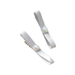 Paire de barrettes à nœuds gris argenté avec perles fantaisie irisées sur fond blanc uni