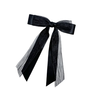 Detail of elegant black double-layered bow hair clip with long satin and organza ribbons