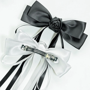Elegant oversized satin bow hair clips with rose detail and long flowing ribbons