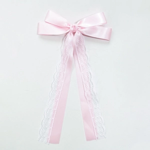Détail du nœud en satin rose avec bords en dentelle blanche et longs rubans élégants