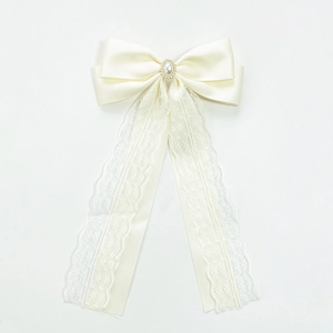 Elegant ivory satin bow hair clip with lace ribbons, pearl, and crystal accents
