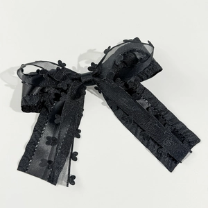 Sweet black layered bow hair clip with heart lace and long tassels on white backdrop