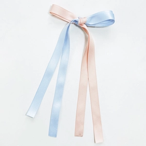 Detailed view of bicolor pink and blue satin ribbon bow hair clip with glossy silk finish