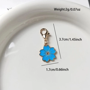 Detail eines blauen Kirschblütenanhängers mit goldenem Metallboden und Maßen 3,7 cm Höhe