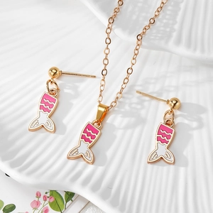 Detailed close-up of golden mermaid tail jewelry set with pink enamel on seashell