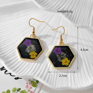 Detail view of hexagonal resin earrings with dried flowers and gold leaf dimensions