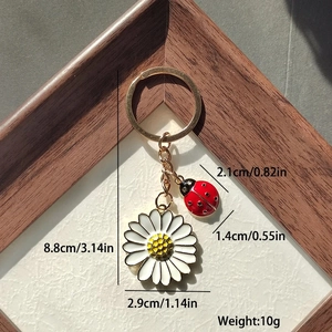 Vue détaillée des breloques marguerite et coccinelle avec mesures de taille