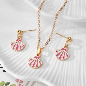 Detail view of pink enamel shell necklace and matching stud earrings on white ceramic