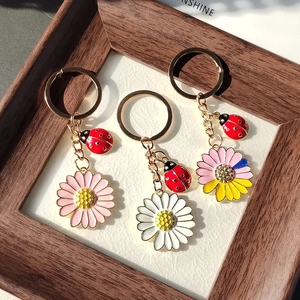 Détails de porte-clés marguerite et coccinelle avec pétales en émail coloré et texture métal