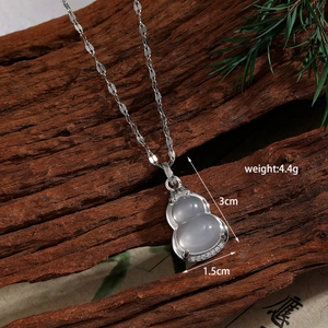 Macro view of silver hulu pendant with white zircon on a sleek steel chain